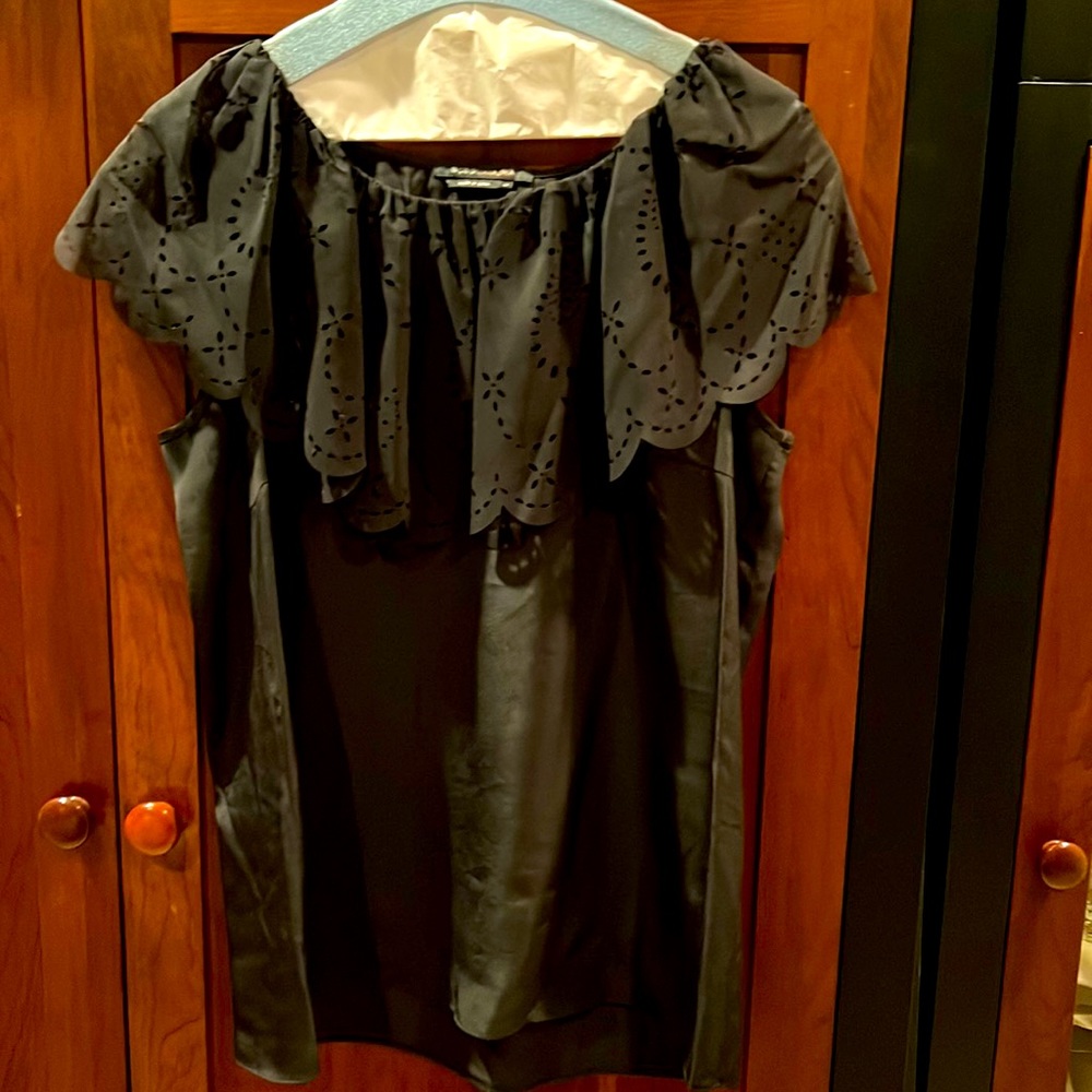 BCBGMAXAZRIA black sleeveless top with cutout overlay.